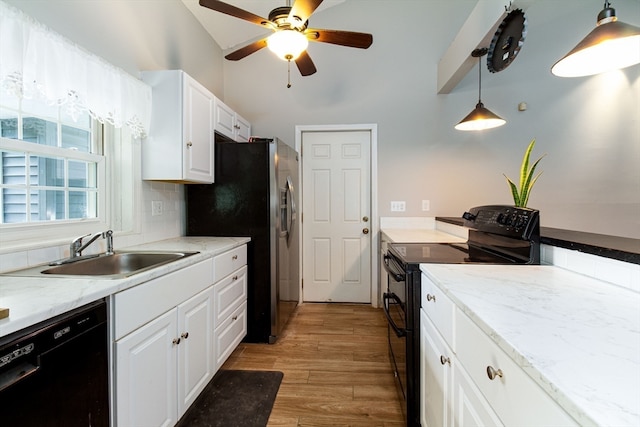 kitchen featuring white cabinetry, sink, hanging light fixtures, light hardwood / wood-style floors, and black appliances