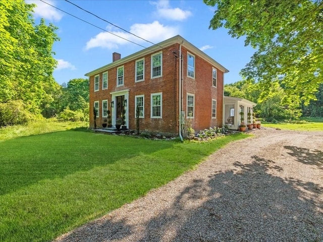 131 Cedar St, Middleboro, MA 02346 - view of front of home featuring a chimney, a front yard, brick siding, and dirt driveway
