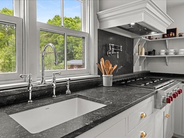 131 Cedar St, Middleboro, MA 02346 - kitchen with custom range hood, a sink, stainless steel gas cooktop, white cabinetry, and dark stone counters