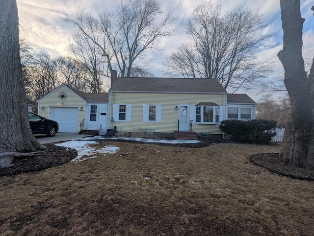 view of front facade with entry steps, a garage, concrete driveway, a front lawn, and a chimney