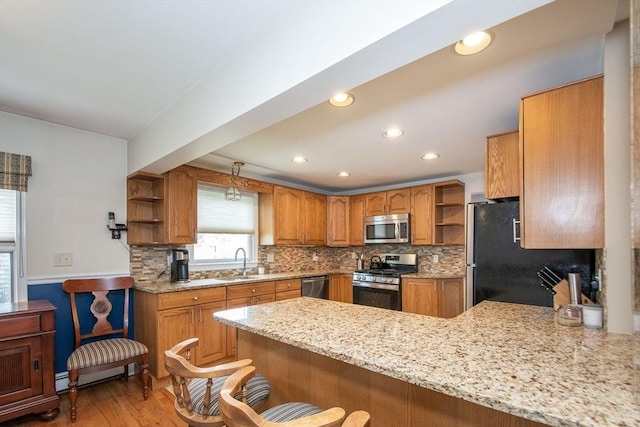 25 11th Rd, Marshfield, MA 02050 - kitchen with stainless steel appliances, open shelves, a sink, a peninsula, and brown cabinets