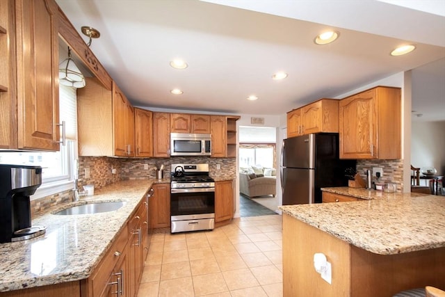 25 11th Rd, Marshfield, MA 02050 - kitchen with stainless steel appliances, a sink, decorative backsplash, a peninsula, and light stone countertops
