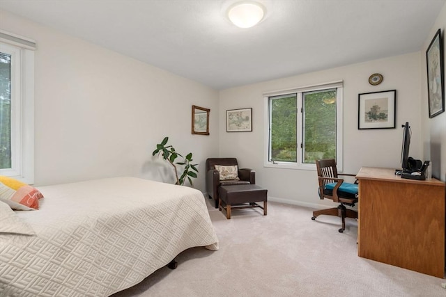 bedroom featuring light colored carpet, a desk, and baseboards