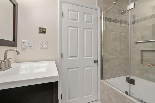 full bathroom with a tile shower and vanity