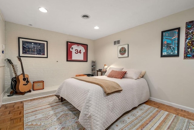 bedroom with baseboards, recessed lighting, and brick wall