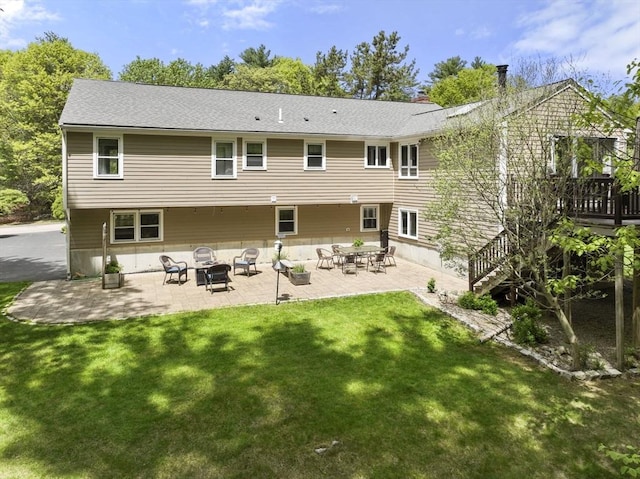 rear view of house with a yard, a patio, a deck, and an outdoor fire pit