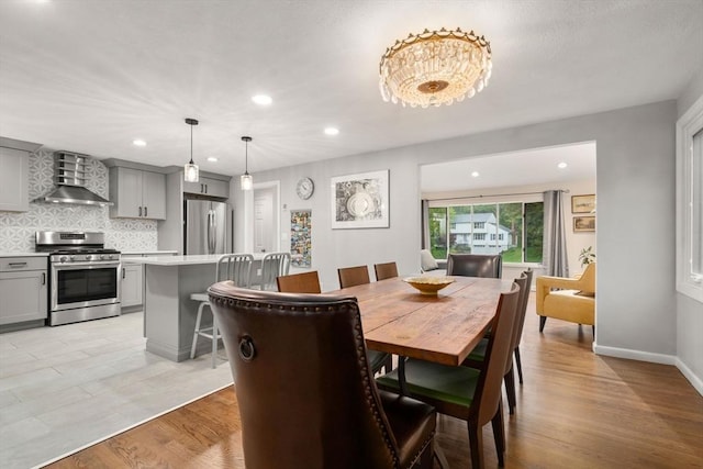 dining room with recessed lighting, light wood finished floors, and baseboards