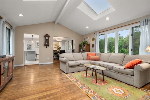living area with light wood finished floors, a skylight, baseboards, and recessed lighting