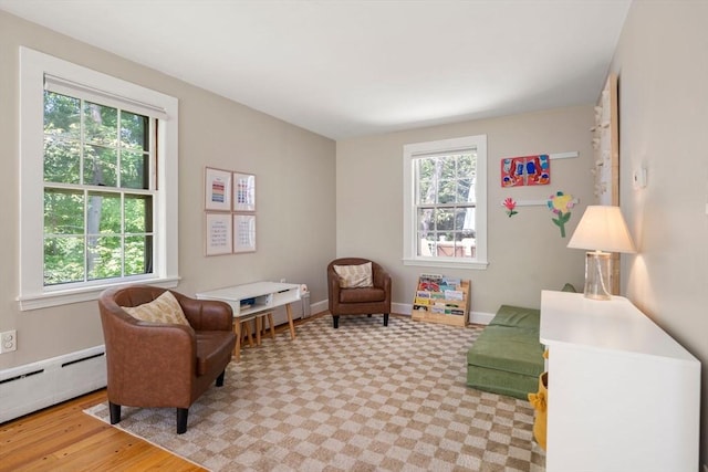 38 Fairmount Rd, Reading, MA 01867 - living area with a baseboard heating unit and light wood-style floors