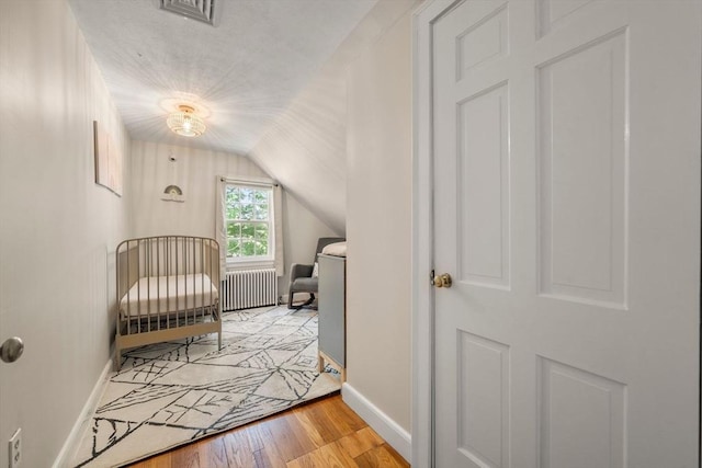 38 Fairmount Rd, Reading, MA 01867 - bedroom with radiator, light wood finished floors, lofted ceiling, and a crib