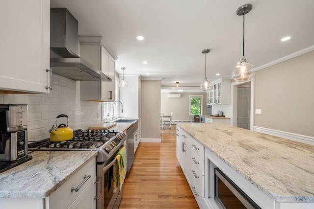 38 Fairmount Rd, Reading, MA 01867 - kitchen with appliances with stainless steel finishes, wall chimney range hood, light wood-style flooring, ornamental molding, and decorative backsplash