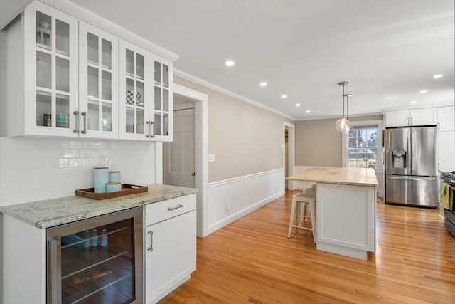 38 Fairmount Rd, Reading, MA 01867 - kitchen featuring stainless steel refrigerator with ice dispenser, wine cooler, ornamental molding, white cabinets, and backsplash