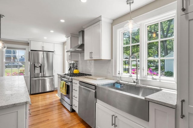 38 Fairmount Rd, Reading, MA 01867 - kitchen featuring appliances with stainless steel finishes, wall chimney exhaust hood, backsplash, white cabinets, and recessed lighting