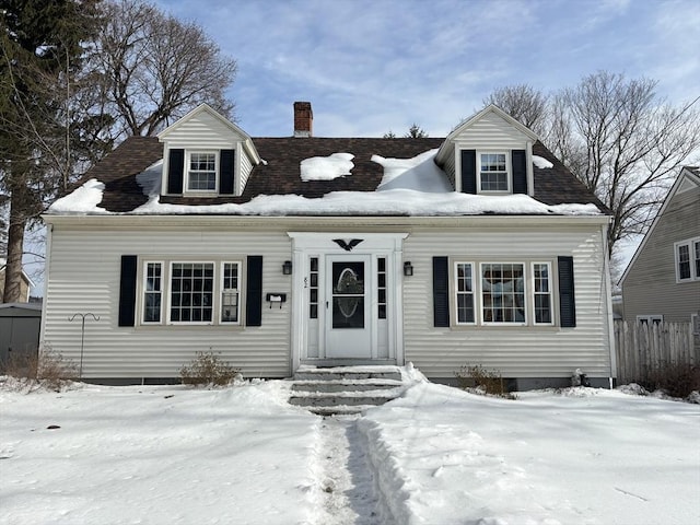 cape cod-style house featuring a chimney