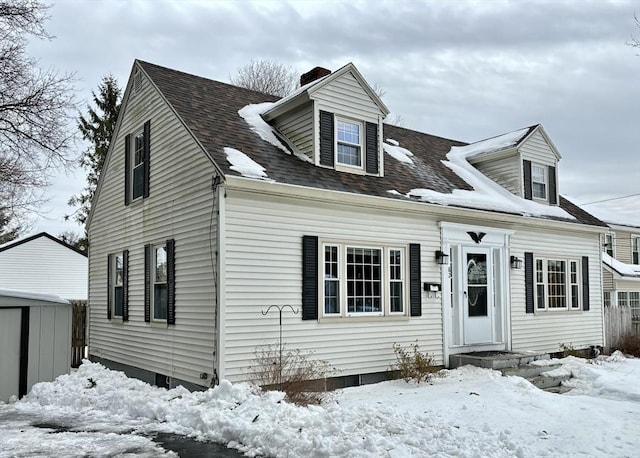 cape cod-style house featuring a garage and a shingled roof