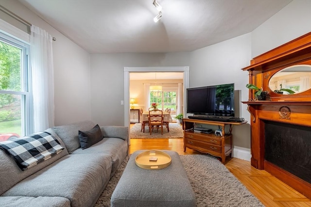 57 Clapp St, Walpole, MA 02081 - living area with rail lighting, light wood-style flooring, and a fireplace with flush hearth