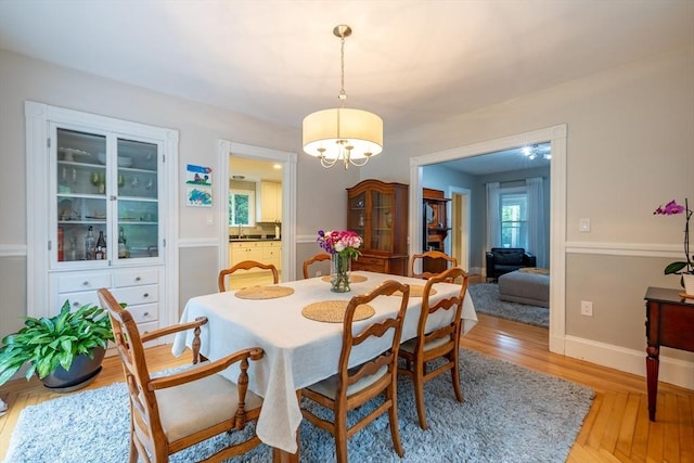 57 Clapp St, Walpole, MA 02081 - dining room with light wood finished floors, a chandelier, and baseboards