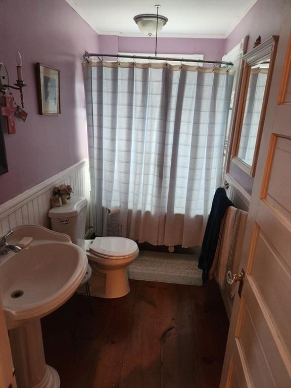 bathroom featuring shower / tub combo, wainscoting, wood finished floors, and toilet