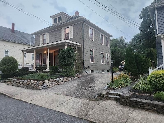 american foursquare style home with driveway and a chimney