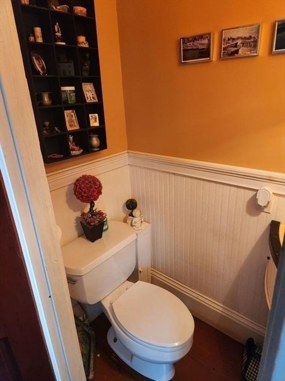 bathroom featuring a wainscoted wall and toilet