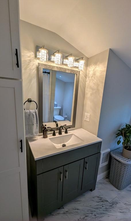 3 Bennett St, Hudson, MA 01749 - bathroom featuring marble finish flooring, vanity, and vaulted ceiling