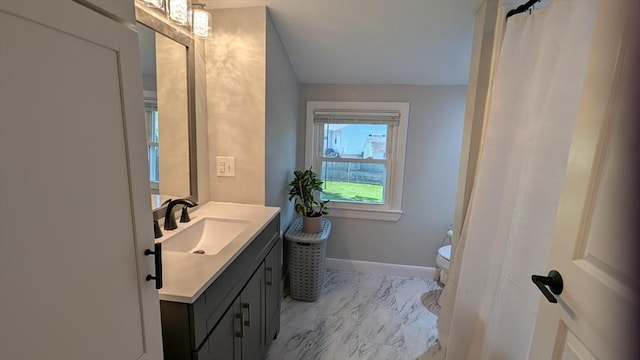 3 Bennett St, Hudson, MA 01749 - full bathroom with vanity, marble look tiles, toilet, and baseboards