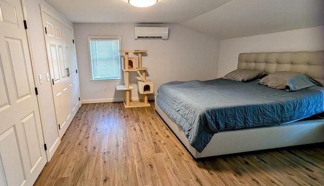 3 Bennett St, Hudson, MA 01749 - bedroom featuring a wall mounted AC, light wood-style flooring, baseboards, and vaulted ceiling
