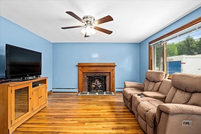 9 Lillian Rd, Acton, MA 01720 - living area with a baseboard radiator, light wood-style flooring, baseboard heating, a ceiling fan, and a fireplace