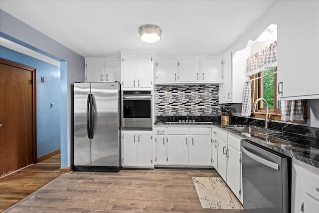 9 Lillian Rd, Acton, MA 01720 - kitchen with appliances with stainless steel finishes, white cabinets, backsplash, a sink, and wood finished floors