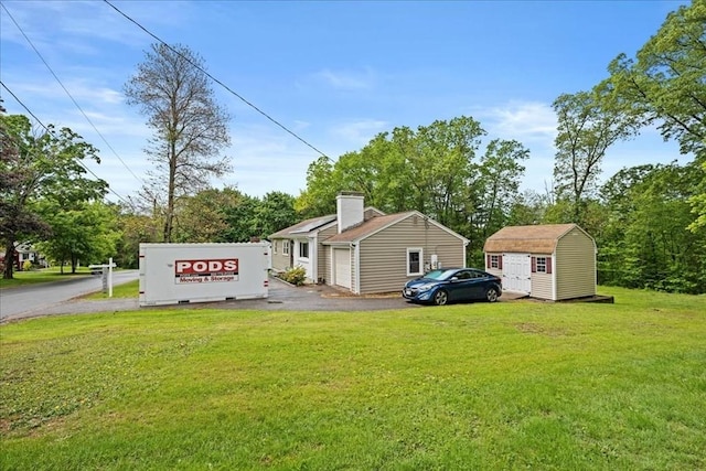 9 Lillian Rd, Acton, MA 01720 - view of side of property featuring a yard, a chimney, and asphalt driveway
