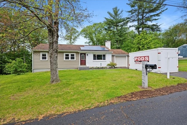9 Lillian Rd, Acton, MA 01720 - view of front facade with solar panels, a front yard, a chimney, and a garage
