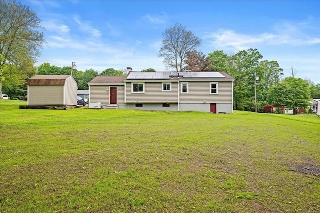 9 Lillian Rd, Acton, MA 01720 - rear view of house with entry steps, roof mounted solar panels, and a lawn