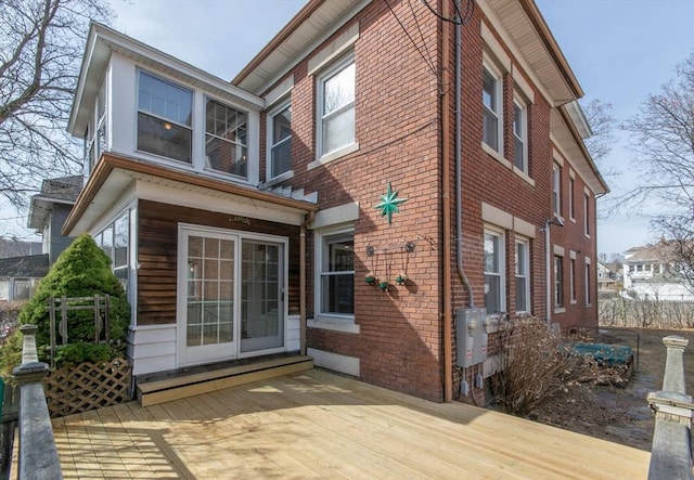 rear view of property with brick siding and a wooden deck