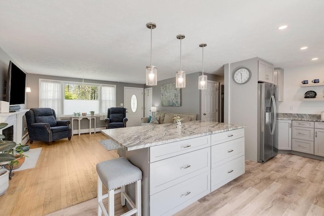 853 Sandwich, Falmouth, MA 02536 - kitchen featuring stainless steel fridge with ice dispenser, open floor plan, light wood-style floors, a kitchen breakfast bar, and recessed lighting