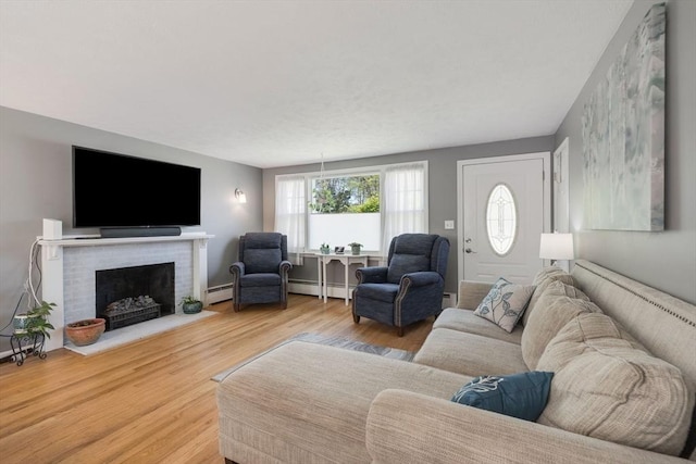 853 Sandwich, Falmouth, MA 02536 - living area featuring baseboard heating, wood finished floors, and a fireplace