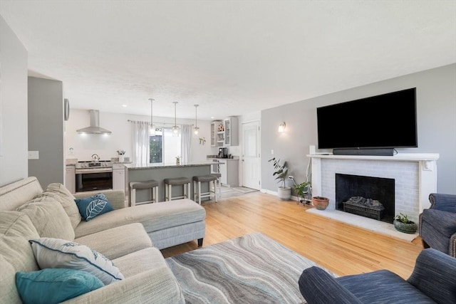 853 Sandwich, Falmouth, MA 02536 - living room with light wood-style floors, a brick fireplace, and baseboards