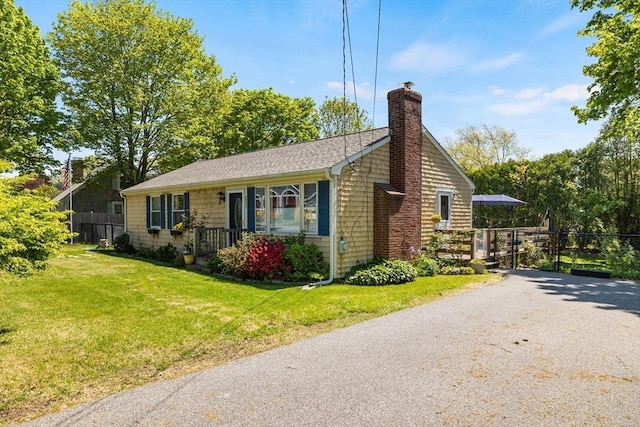 853 Sandwich, Falmouth, MA 02536 - view of home's exterior with a chimney, roof with shingles, and driveway