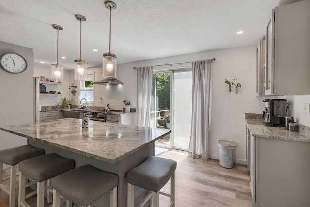 853 Sandwich, Falmouth, MA 02536 - kitchen with exhaust hood, a kitchen breakfast bar, stainless steel electric stove, light stone counters, and recessed lighting