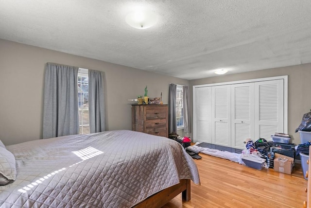 bedroom with wood finished floors, a closet, and a textured ceiling