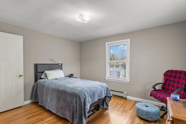 bedroom featuring baseboards, baseboard heating, and wood finished floors