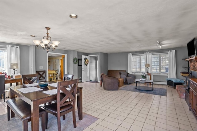 dining space with light tile patterned floors and a chandelier