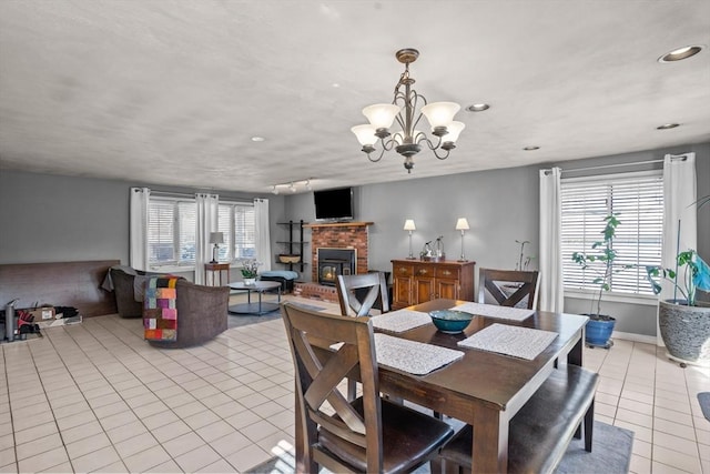 dining area featuring a brick fireplace, baseboards, recessed lighting, an inviting chandelier, and light tile patterned flooring