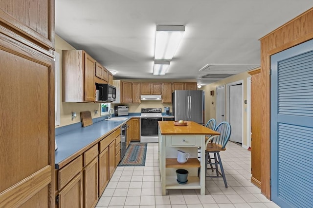 kitchen with a kitchen bar, under cabinet range hood, open shelves, a center island, and appliances with stainless steel finishes