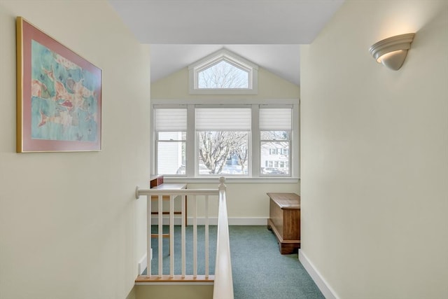 hallway featuring vaulted ceiling and carpet