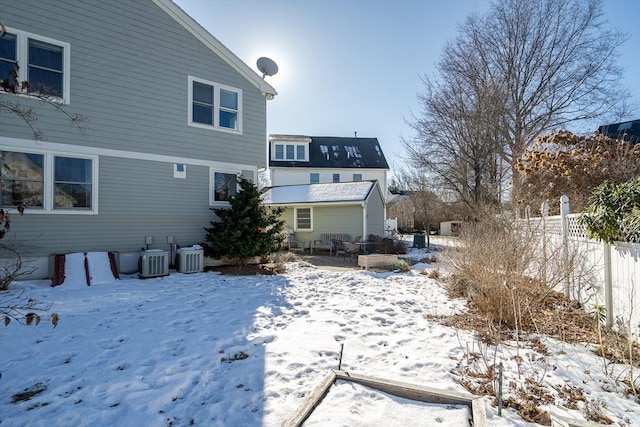 snow covered house with central air condition unit