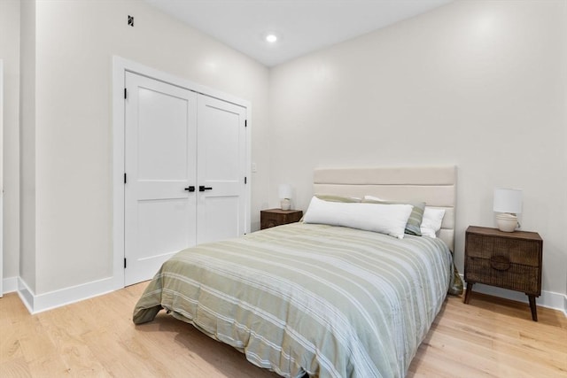 bedroom with light hardwood / wood-style floors and a closet