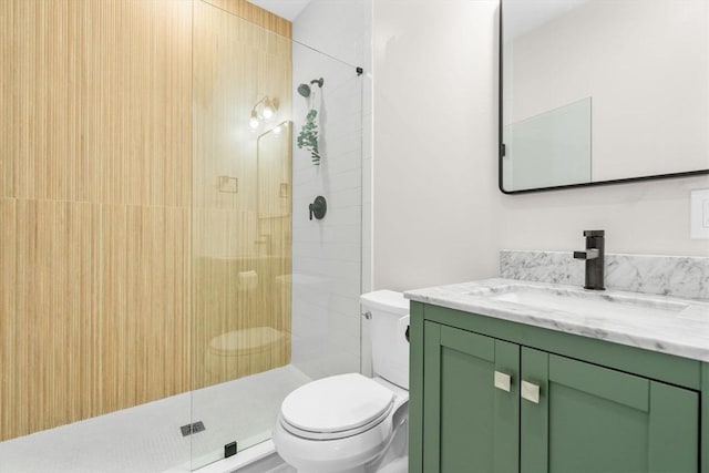 bathroom featuring vanity, toilet, and a tile shower