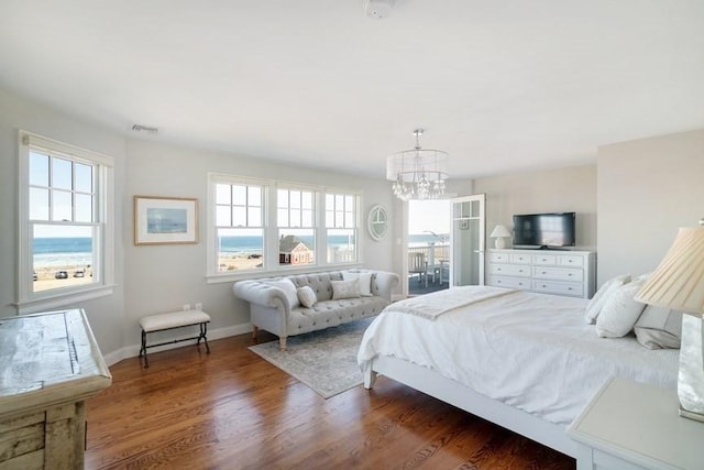 bedroom with dark wood-type flooring, multiple windows, and a chandelier