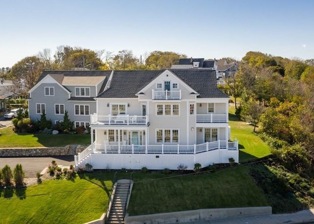 back of house featuring a balcony and a yard