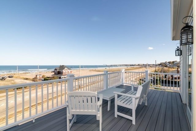 wooden deck with a beach view and a water view